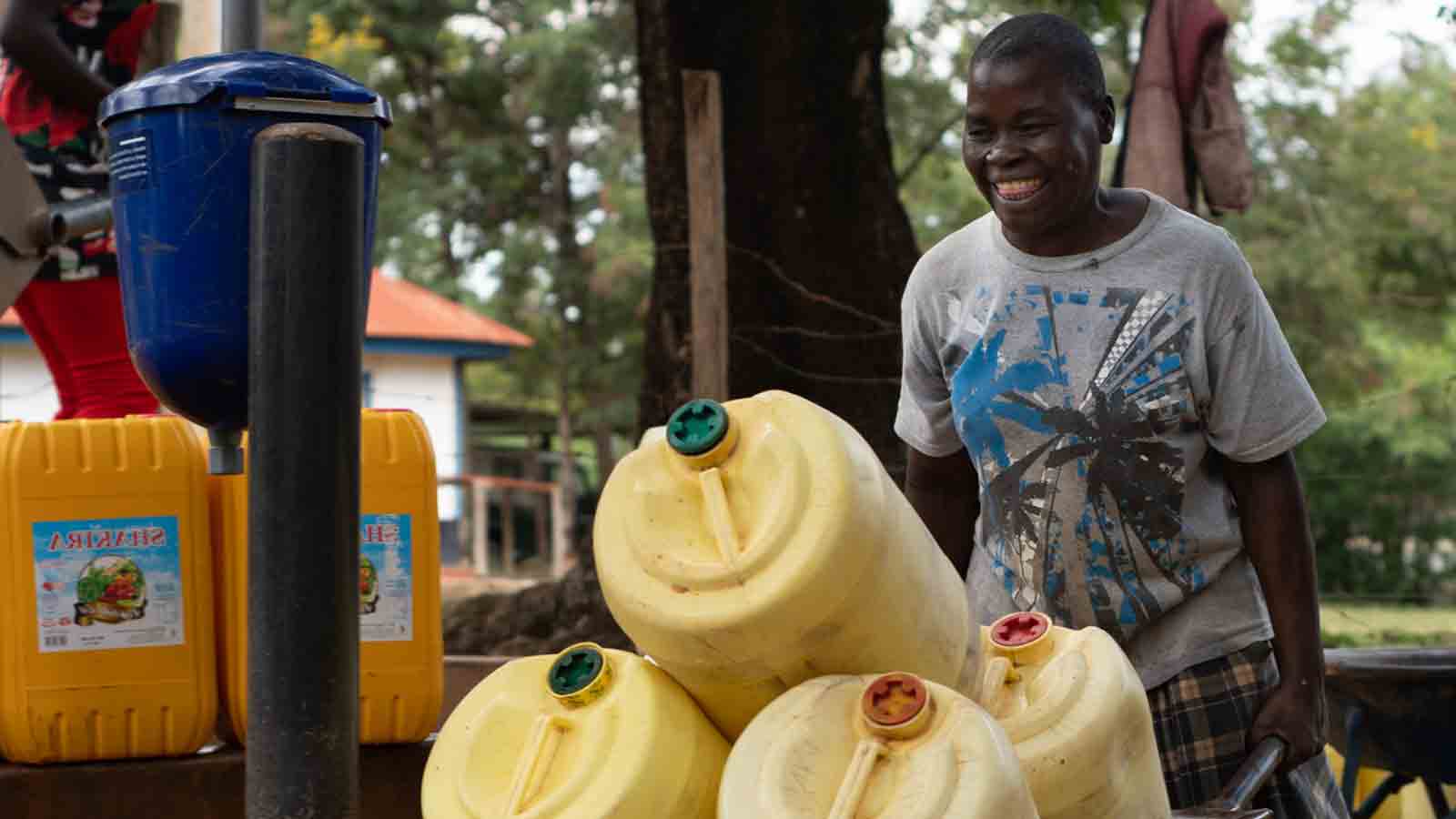 Kenyan carrying plastic buckets with a wheel borrow 