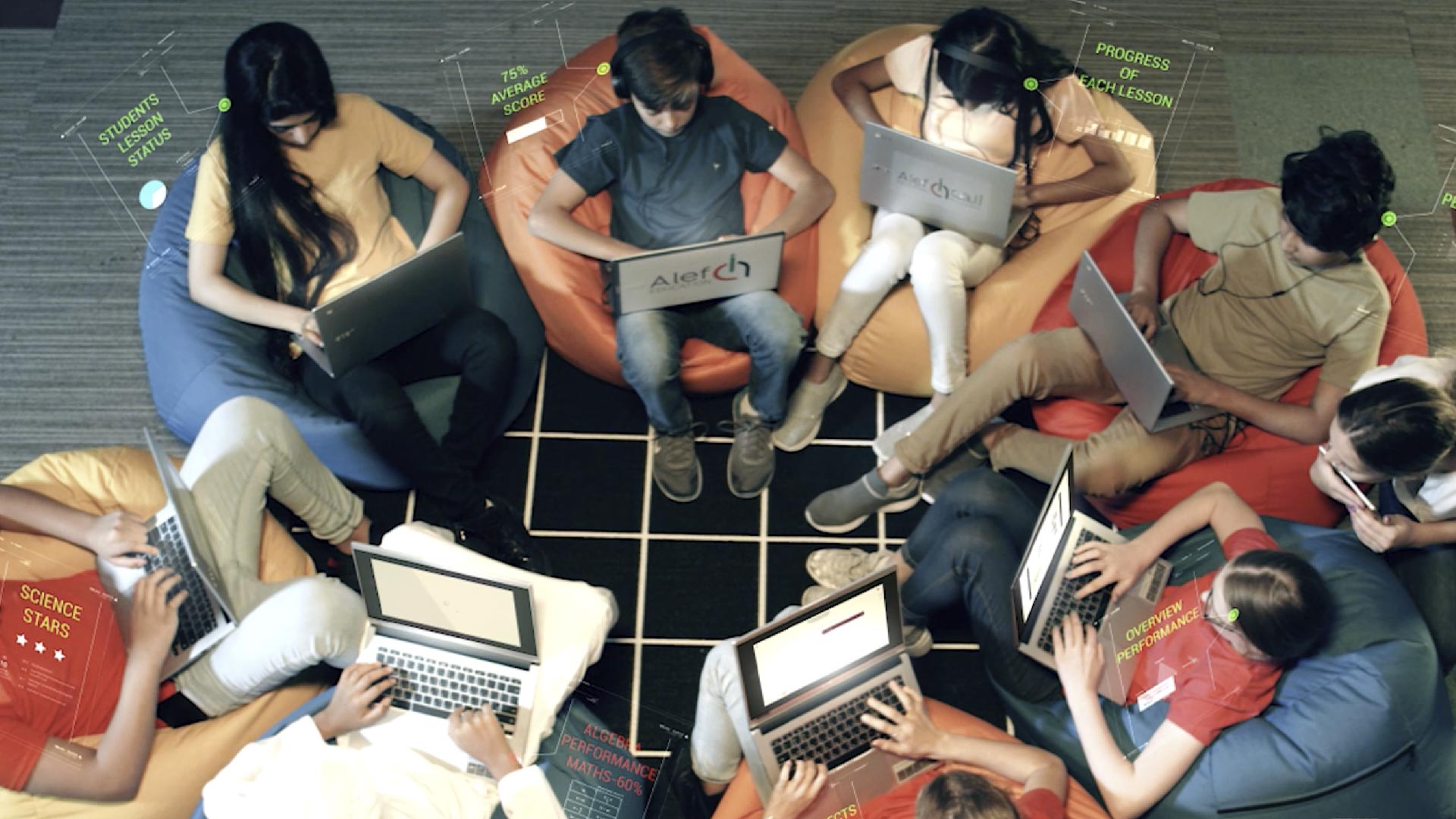 A group of children sitting in a circle, each learning on their own laptops