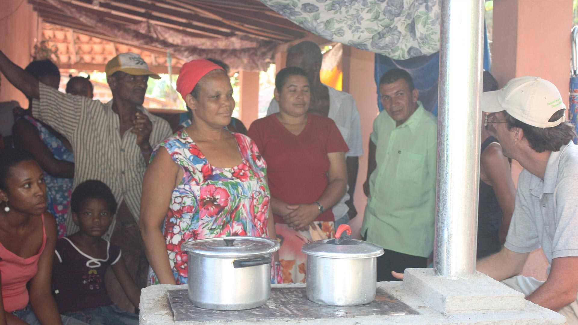 Local men and women from Brazil standing around an efficient cookstove