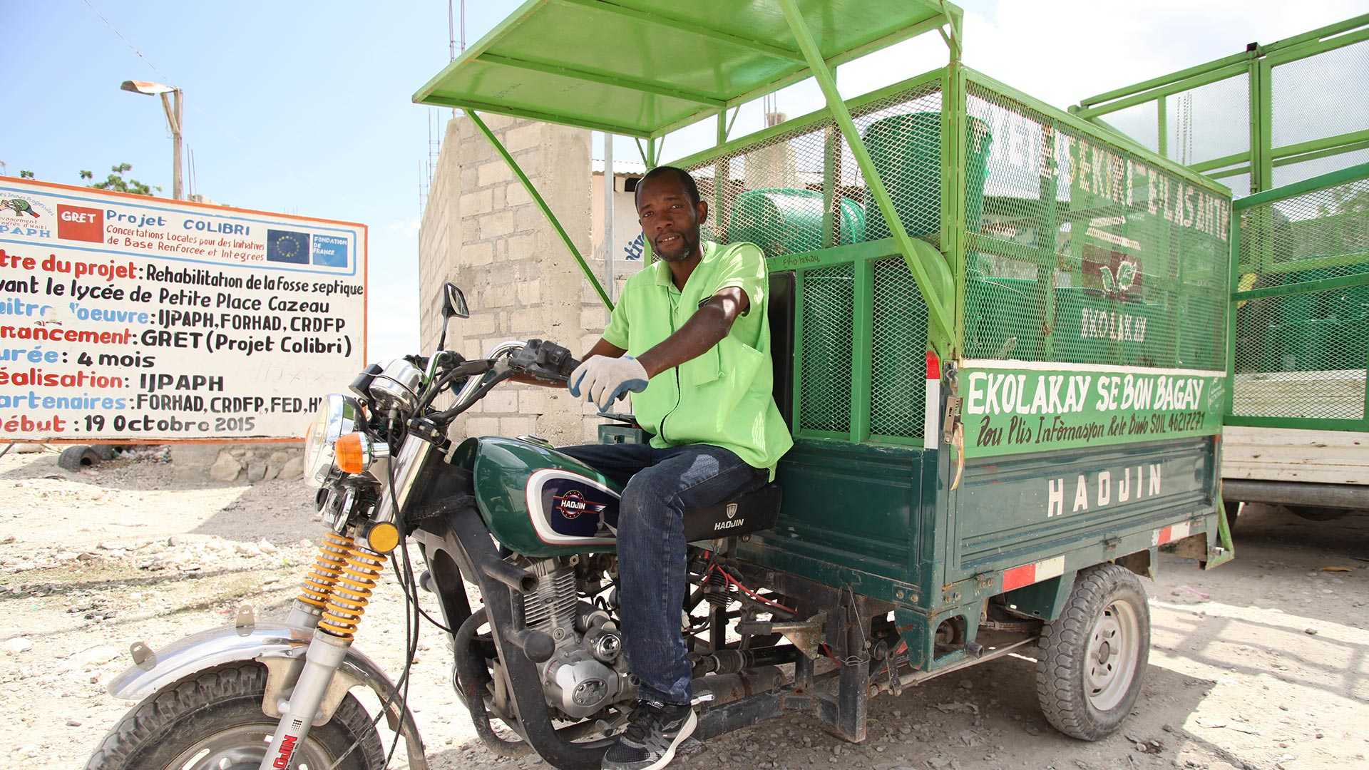 A man driving a vehicle carrying waste collected from homes in Haiti to be turned into compost